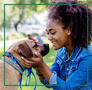 Meet the Pros! Woman holding dogs face in hands happily talking to.